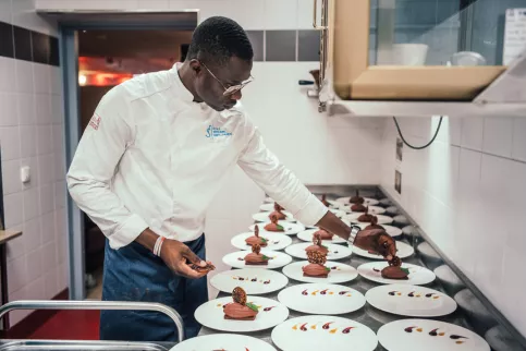 Jeune homme dressant des assiettes de desserts
